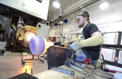 students in the hot shop working on blown glass pieces