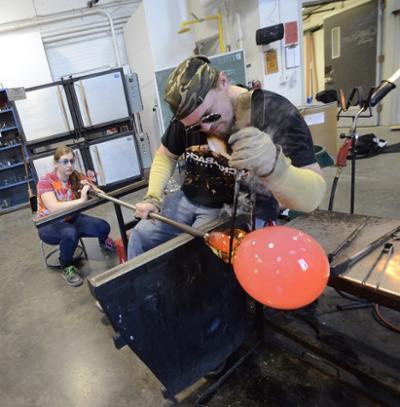 student clamping off a piece of glass from a pipe